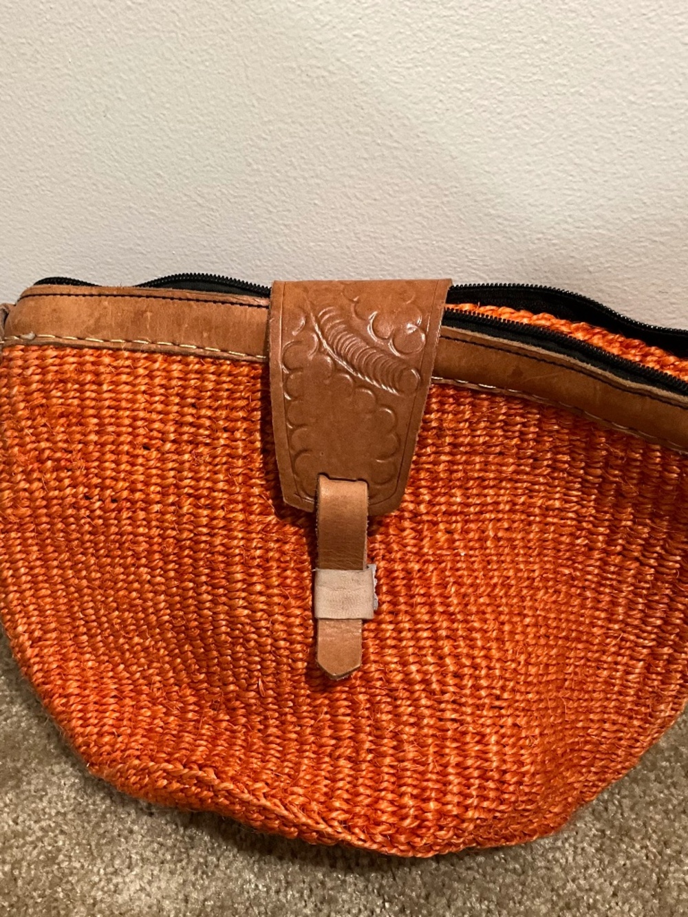 Lined Kenyan sisal Kiondo bag with embossed leather strap closure, orange